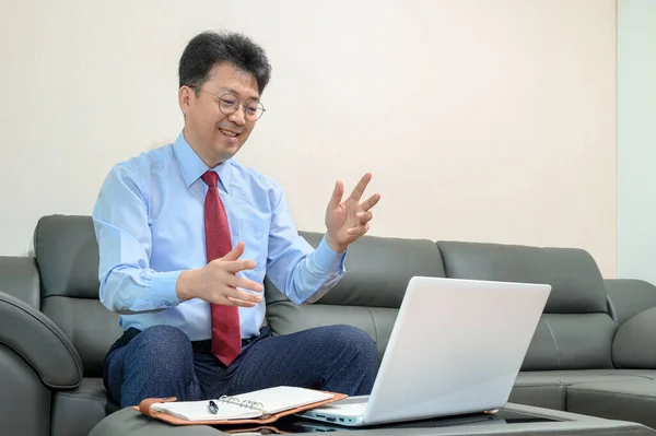 Azjatycki Biznesmen Średnim Wieku Siedzący Kanapie Salonie Pracujący Domu Koncepcja — Zdjęcie stockowe