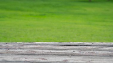 Ahşap güverte ve bulanık doğa yeşil çimen arka plan.