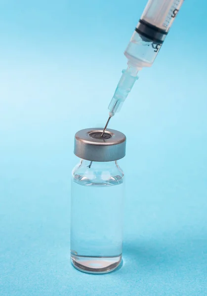 注射器と青の背景にアンプルとワクチンの概念 — ストック写真