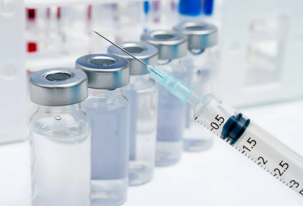 Концепция вакцины со шприцем и ампулой на белом фоне. — стоковое фото