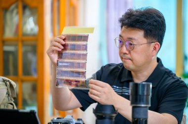 Hobisi 35 mm / 135 mm 'lik SLR kamera olan orta yaşlı bir adam..