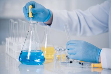 Laboratuvarda çalışan bir bilim adamının eli. Aşı geliştirme kavramı.