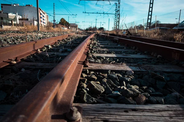 In the image can see a train tracks and there are rain changes as well.