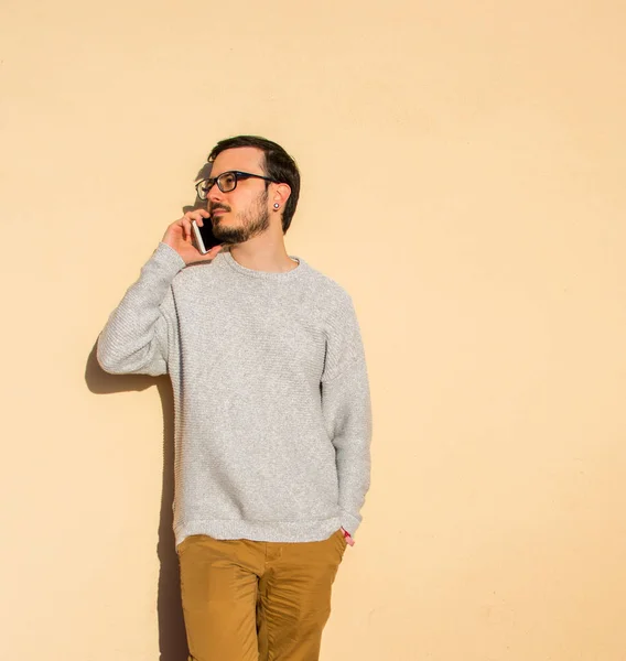 A portrait of man standing on a rooftop making a phone call. Balcony, talking.