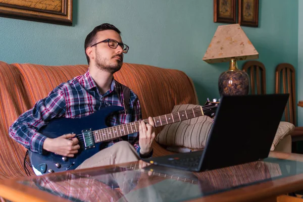 Man learn playing electric guitar at home