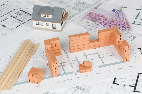 模型房屋建设与砖在蓝图和500欧元钞票 — 图库照片