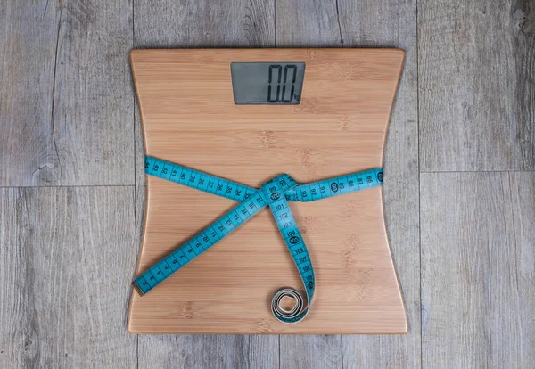 Fita métrica enrolada em torno da balança de peso. Perder peso conceito . — Fotografia de Stock