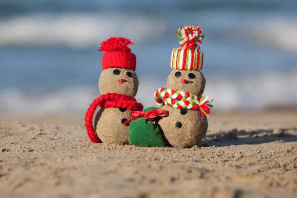 Dois pequenos bonecos de neve arenosos na praia tropical . — Fotografia de Stock