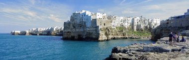 Polignano A Mare, İtalya - 29 Mart 2018: Adriyatik Denizi deniz kayalıklarla Adriyatik Denizi Polignano içinde yükselen bir Mare, Puglia, İtalya mağaralar ile dramatik manzaralı kıyısı insanlar