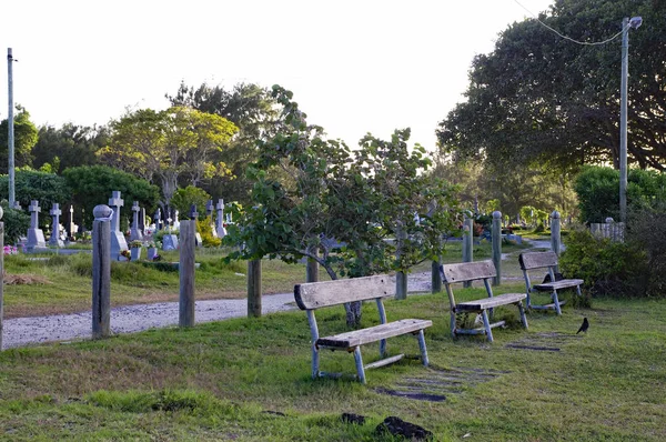 CAP MALHEUREUX / MAURICIUS - 13 DE AGOSTO DE 2018: Tres bancos en el cementerio tradicional con vista a la costa de Cap Malheureux, Isla Mauricio — Foto de Stock