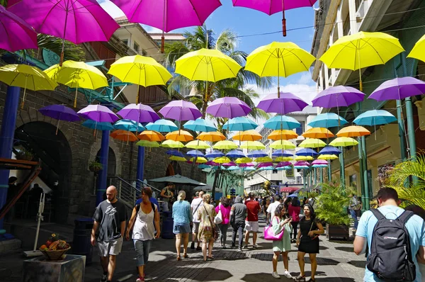 PORT LOUIS / MAURITIUS - 16 AOÛT 2018 : Des gens traversent l'allée principale de Caudan Waterfront à Maurice. La ville est le centre économique, culturel, politique du pays et la ville la plus peuplée . Image En Vente