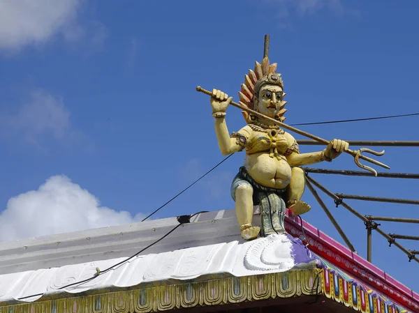 Malá socha lorda Šivy na střeše jednoho z mnoha hinduistických chrámů na Mauriciu — Stock fotografie
