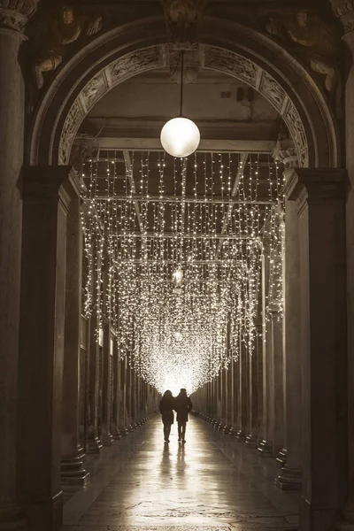 Geceleri Noel'de Venedik ustaca sokakta yürüyen insan silüeti