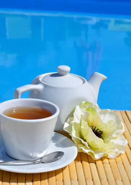 Chá de camomila em uma xícara na frente da piscina . — Fotografia de Stock