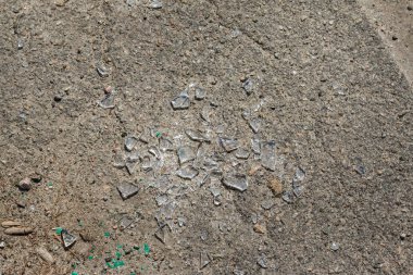 asfalt yüzeyinde kırık cam. şehirde sokak vandalizmi. asfalt beton yolda kırık cam parçaları