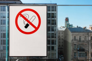 beyaz etiket üzerinde sigara işareti yok, arka planda şehir binaları