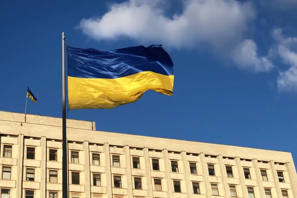 Український прапор, що розвівся на вітрі, проти будівлі Центральної виборчої комісії — стокове фото