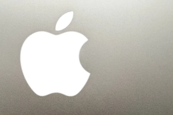 ぼやけたアルミニウムの背景に白いアップル社のロゴのクローズアップ — ストック写真