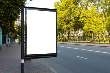 Sokaktaki ilan panosu. White Outdoor Reklamcılık. Reklam tasarımı için tasarım. Parkın yakınında beyaz bir tarlası olan ışıklı sütun.
