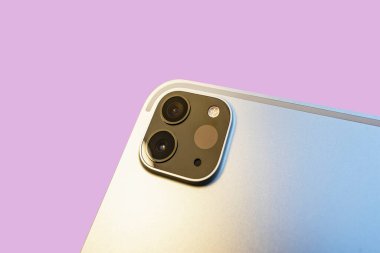 Pembe arka planda tablet bilgisayar kamera sistemine yakın çekim. Modern bir dijital çokluortam aygıtında ışık algılayıcı tarayıcı