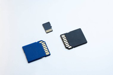 Gri arka planda üç mikro SD hafıza kartı, yakın plan, üst görüntü. Veri depolama kavramı
