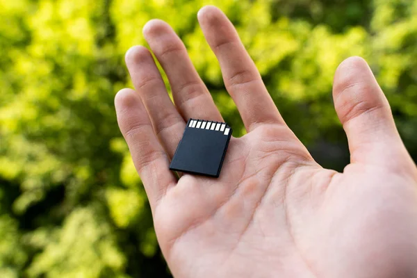 Black Flash Card Hand Man Blurred Green Leaves Background Outdoors — Stock Photo, Image