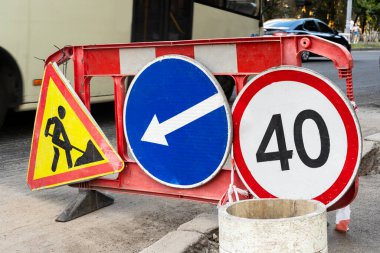 Asfalt yol yüzeyinin tamiri. Tamir edilen yolda duran yol işaretleri.