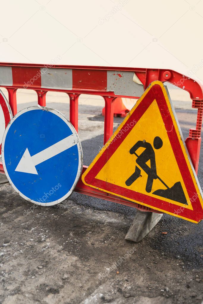 Road marking on the road, warning signs. Direction of detour, sign speed limit 40 and roadworks. Road signs denoting road repairs, speed limit up to 40, detour, vertical image