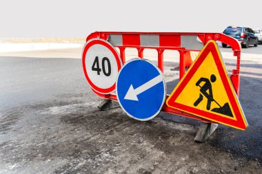 Şehir caddesinde trafik tabelasında çalışıyor. Sapma yönü, hız limiti 40 ve yol çalışması yolu yapım aşamasında.