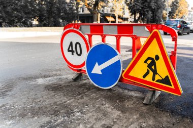 Asfalt yol yüzeyinin tamiri. Yol tabelası tamir edilirken yolda duruyor. Yol tabelasını gösteriyor, hız limiti 40, sapma