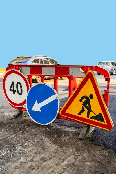 Road marking on the road, warning signs. Direction of detour, sign speed limit 40 and roadworks, vertical image