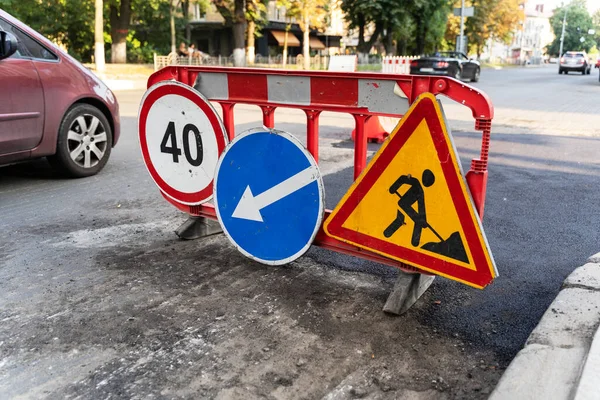 Road marking on the road, warning signs. Direction of detour, sign speed limit 40 and roadworks. Road signs denoting road repairs, speed limit up to 40, detour