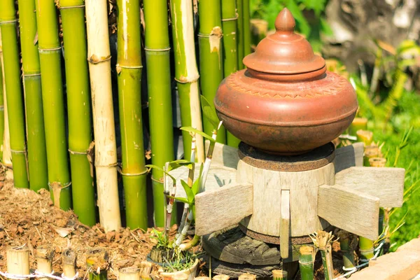 Depolama su için kullanılan ve içinde belgili tanımlık bahçe dekore edilmiş toprak kap.