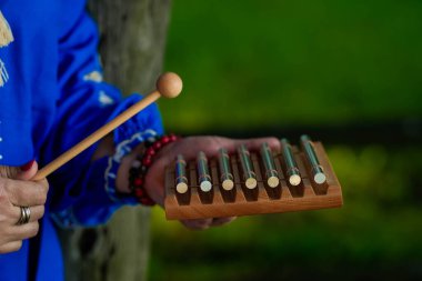 Elinde metal bir ksilofon rüzgar enstrümanı tutan bir kadın. Beden ve ruh için alternatif tıbbi terapi