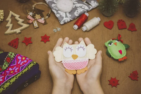 Μαλακό σπιτικό παιχνίδι εκμετάλλευση του παιδιού τα χέρια πάνω στο τραπέζι με το ράψιμο και Χριστούγεννα διακοσμήσεις — Φωτογραφία Αρχείου