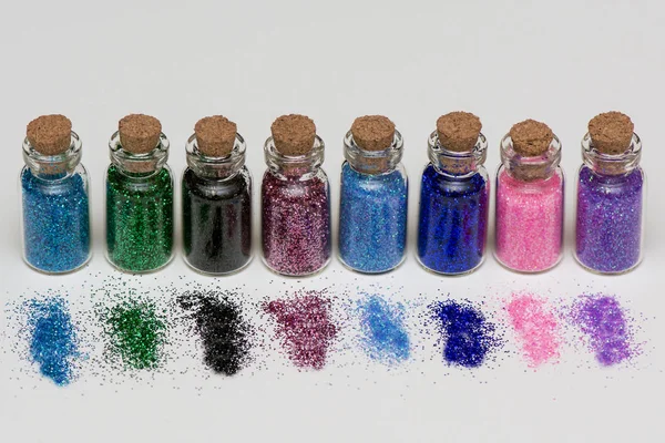 Mångfärgade glitter spik manikyr och makeup i banker på en vit bakgrund. makro — Stockfoto