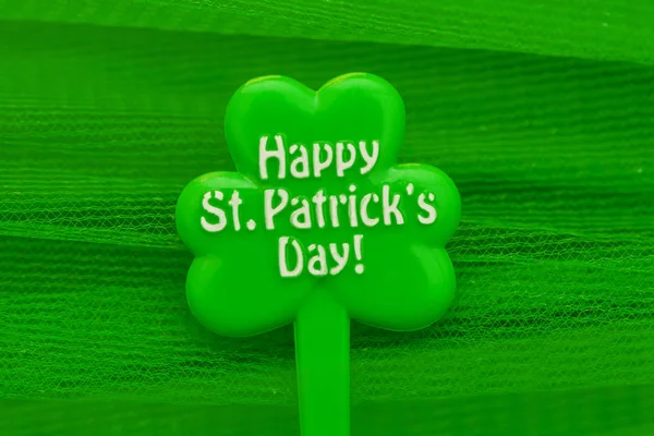 Happy Patrick 's day inscription on green maple leaf on green background — стоковое фото