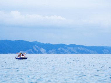 Güneş sis blue mountains karşı mavi dalgalar üzerinde sallanan deniz expanses keyfi teknede