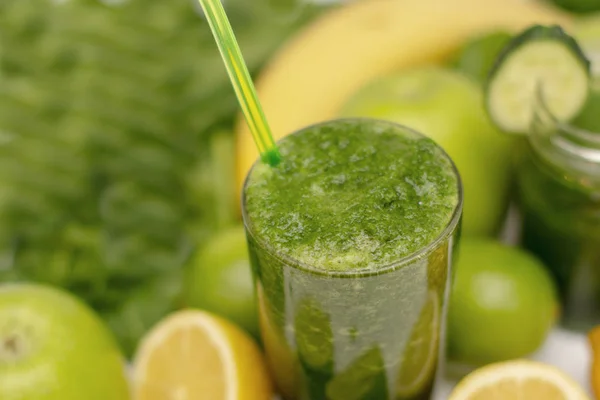 Zöld turmix-egy pohár csésze körül zöld zöldségek és gyümölcsök egészségügyi, diéta és a fogyás, a vegetarianizmus. közelről. blur. — Stock Fotó