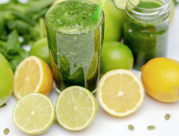 Zöld turmix-egy pohár csésze körül zöld zöldségek és gyümölcsök egészségügyi, diéta és a fogyás, a vegetarianizmus. közelről. blur. — Stock Fotó