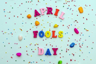 yazıt Nisan Fools Day bir tatil serpantin ile mavi bir arka plan üzerinde renkli parlak tahta harflerle.