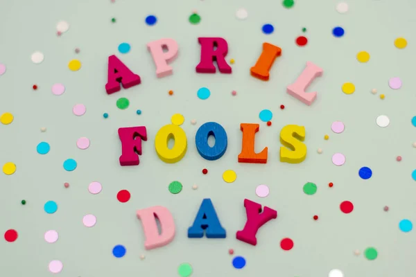 Napis kwietnia Fools Day w kolorowe jasne drewniane liter na niebieskim tle z serpentyn holiday. — Zdjęcie stockowe