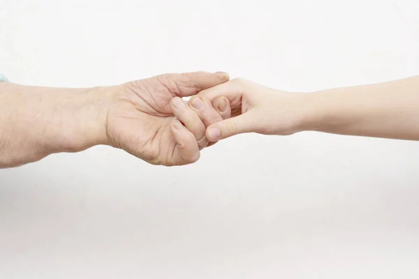 Τα χέρια του γέρου και ένα παιδάκι που κρατάει ένας τον άλλον σε λευκό φόντο. αντίθεση. ιδέα — Φωτογραφία Αρχείου