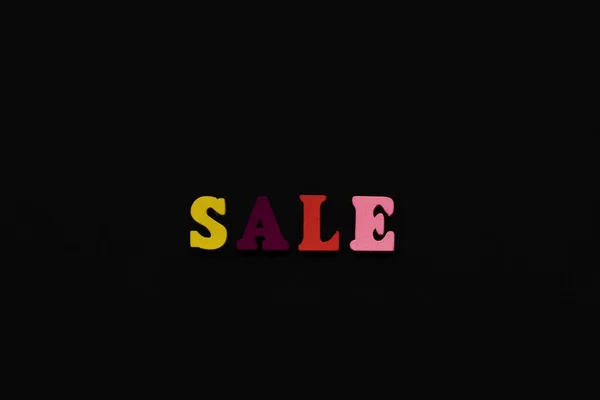 The inscription sale in colored letters on a black background — Stock Photo, Image