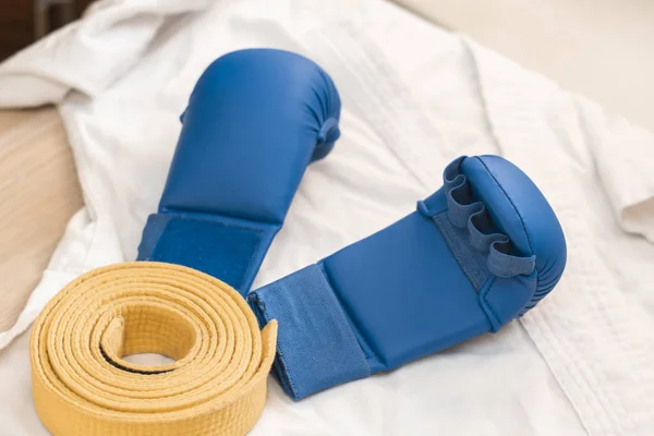Sportutrustning för Karate-vit kimono, foder blått och gult bälte — Stockfoto