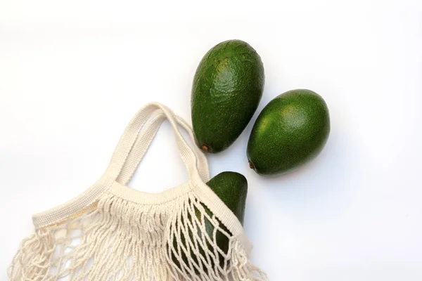 Avocado in een String tas op een witte achtergrond. nul afval. — Stockfoto