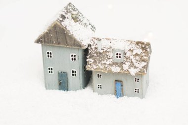 Beyaz karla kaplı arka planda doğal ahşap el yapımı İskandinav Noel rahat oyuncak evler. Minimalizm.