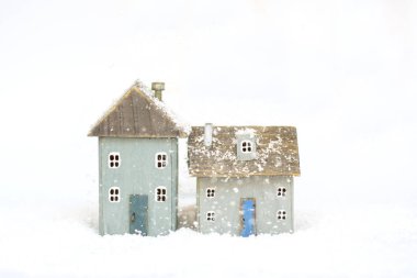 Beyaz karla kaplı arka planda doğal ahşap el yapımı İskandinav Noel rahat oyuncak evler. Minimalizm.