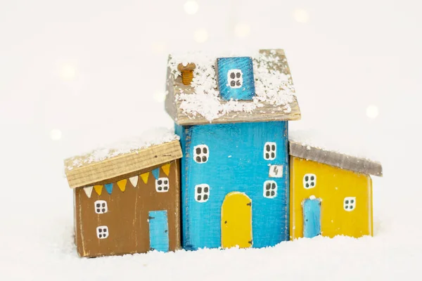 斯堪的纳维亚圣诞舒适的玩具屋,由天然木材手工制作,背景是白雪覆盖。极 简 主义. 免版税图库图片