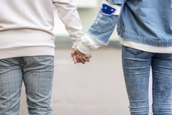 Una joven pareja cogida de la mano con ternura y amor en la calle . — Foto de Stock